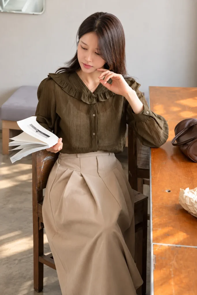 A Ruffle Collar Blouse With a Pleated Beige Skirt