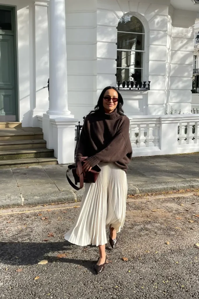 Oversized Brown Turtleneck Over a Cream Pleated Skirt