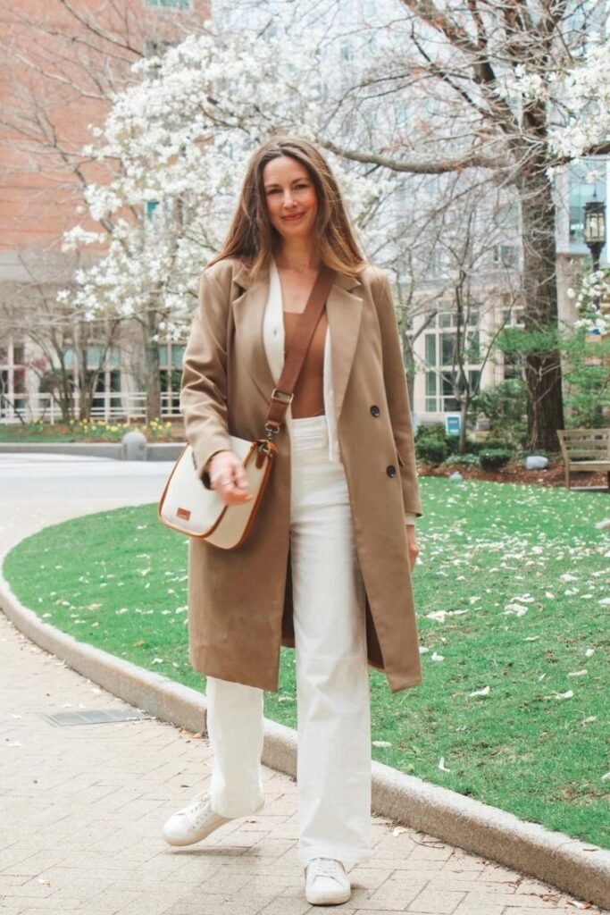 A Camel Coat Over White Wide Leg Trousers