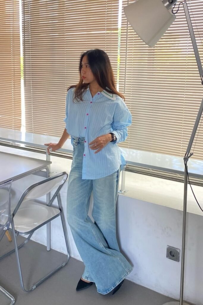 An Oversized Pinstripe Shirt Half Tucked Into Pale Denim