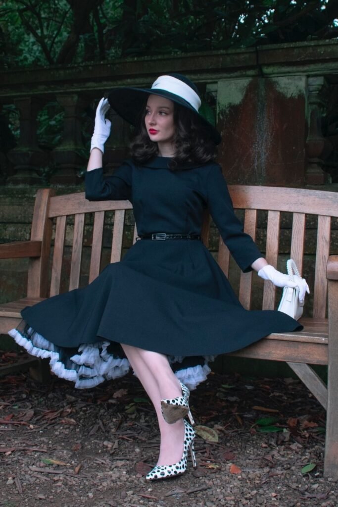 Black Swing Dress With White Gloves and a Wide Brim Hat
