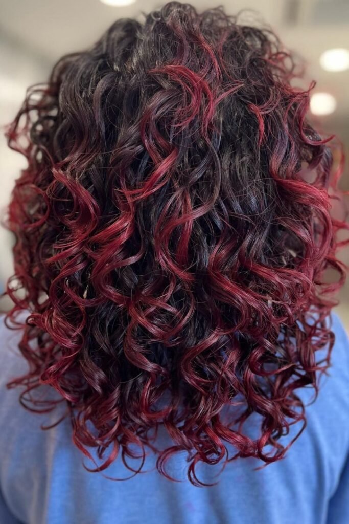 Bright Red Peekaboo Highlights on Natural Curls