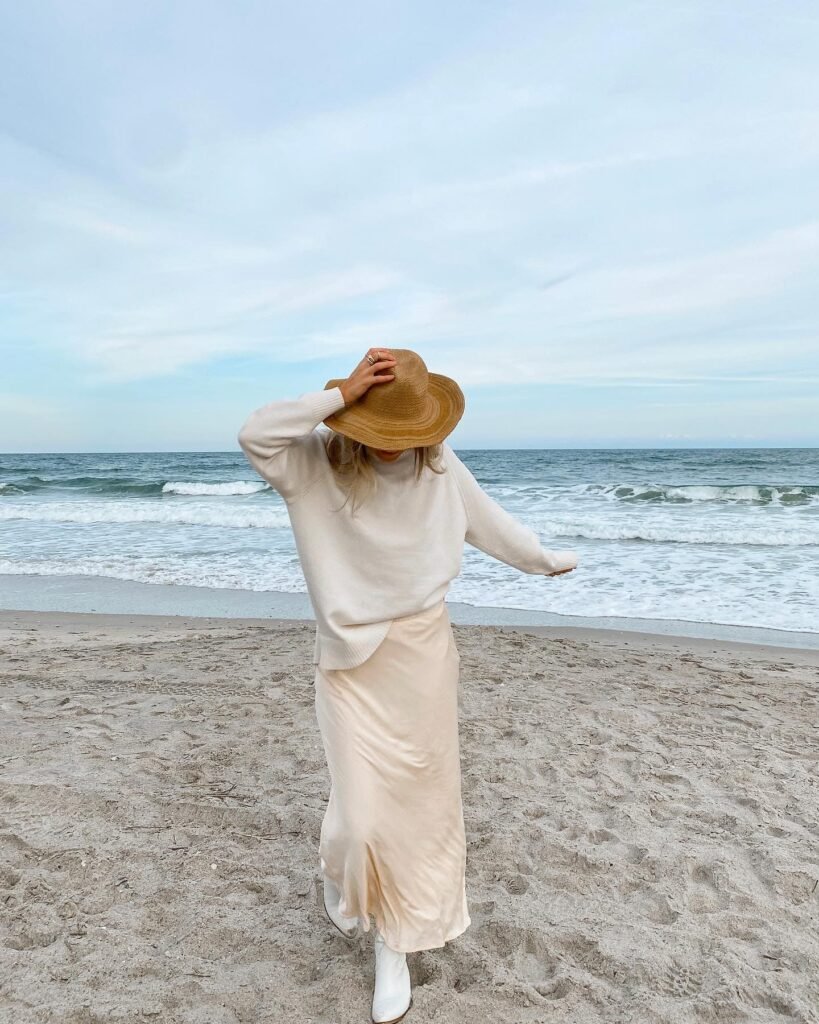 Cream Sweater Over a Satin Slip Skirt With White Boots