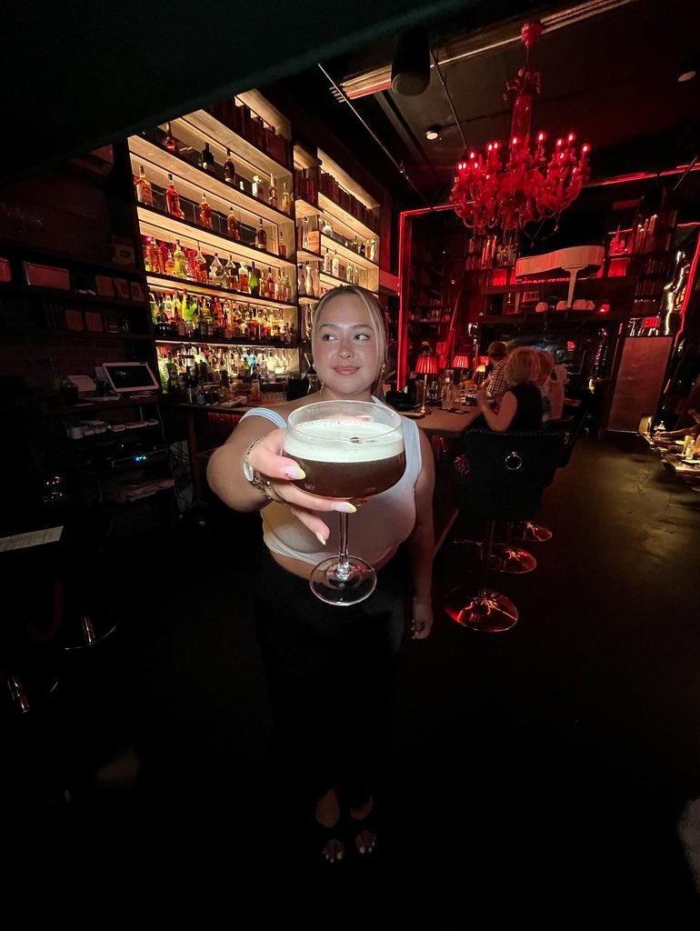 White Tank With a Black Maxi Skirt at a Dark Cocktail Bar